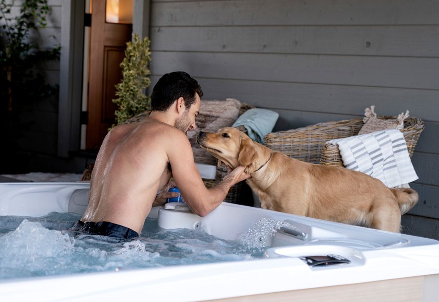 Man and dog beside a Caldera Paradise Reunion hot tub
